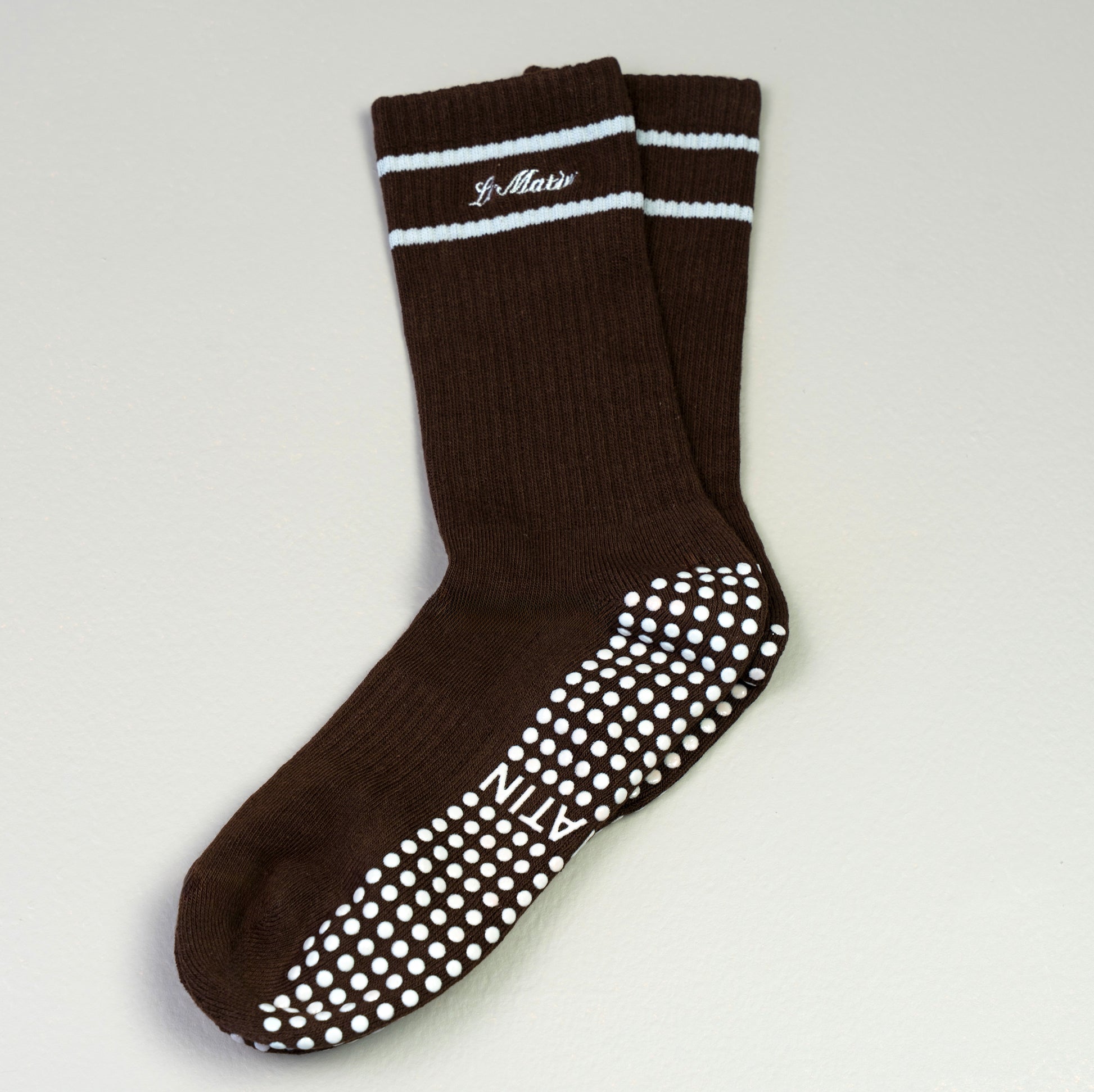 Brown socks with Greysole and striped top with Le Matin branding on a gray background